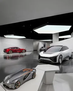 Three futuristic concept cars in red, white, and silver displayed on a glossy floor in a modern exhibition space with black ceiling and white geometric walls.