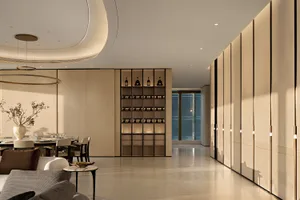 Modern luxury dining room with round chandelier, oak wine cabinet, and neutral-toned seating area