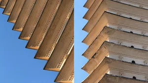 Close-up architectural photograph of a traditional Chinese stone pagoda showing detailed corbelled eaves and layered brackets against a blue sky.