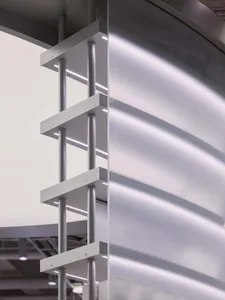Close-up view of a modern architectural glass partition featuring a white anodized aluminum frame with integrated linear LED lighting and cylindrical supports.