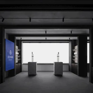 Minimalist concrete retail gallery interior with two central floating display cabinets, built-in shelving, large panoramic window, and blue brand wall for Shouyang Gallery.
