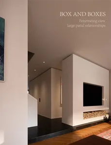 Modern minimalist living room featuring a large white micro-cement fireplace wall with integrated TV and firewood storage, dark tiled floor transitioning to herringbone wood flooring, and a view into a long corridor.