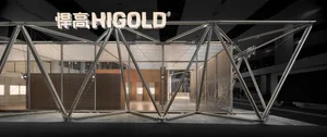Modern stainless steel geometric truss structure forming the entrance to a Higold exhibition booth with illuminated brand signage.