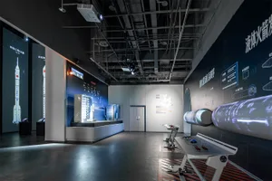Modern science museum exhibition hall displaying Chinese rockets, satellite models, large projection walls with technical diagrams, and interactive control stations under dramatic industrial lighting.
