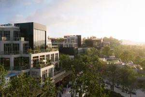 Aerial view of a modern architectural complex featuring extensive glass curtain walls, concrete structures, rooftop gardens, and pedestrian walkways at sunset.
