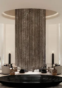 Luxurious modern lobby featuring a massive sparkling crystal bead curtain hanging from a circular ceiling, surrounded by white curved sofas and black sculptural coffee tables on a light marble floor.