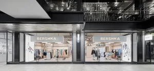 現代Bershka零售店，採用全高玻璃立面、黑色金屬框架與發光招牌，位於當代購物中心。