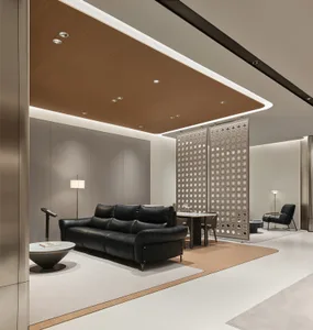 Modern luxury lounge with black leather sofa, curved wood ceiling with recessed lighting, decorative lattice room divider, and neutral-toned walls.
