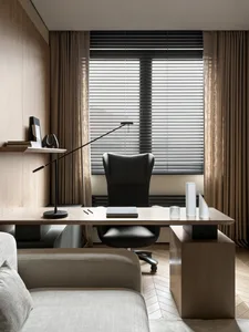 Modern minimalist home office featuring a light oak desk, black leather executive chair, articulated black desk lamp, and neutral beige curtains with wooden herringbone flooring.