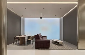 Modern minimalist living and dining room featuring a brown leather modular sofa, light wood and marble dining table with beige chairs, and a large blue gradient accent wall.