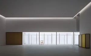 Modern minimalist white staircase featuring a tall vertical window, floating wooden storage cabinet, and a two-tone wooden box with yellow interior on the floor.