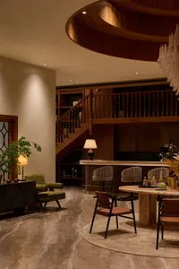 Luxurious double-height living and dining area featuring a dramatic curved walnut wood ceiling, marble floor, built-in bookshelves, and a mix of contemporary and mid-century furniture.