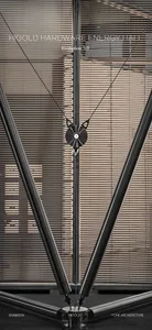 Close-up view of a modern stainless steel tension structure with central circular hub and radiating cables forming a V-shape in an exhibition space.