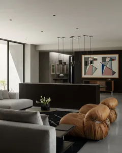 Modern living room featuring a brown leather bubble sofa, grey sectional, dark wood console, large abstract geometric painting, and multiple pendant lights.