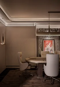 Modern luxury private poker room featuring a round wooden table, four taupe velvet swivel chairs, geometric wood-paneled wall, marble accent wall with red abstract art, and linear pendant lighting.