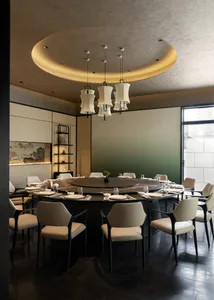 Elegant modern Chinese dining room with a large round black marble lazy-Susan table, cream upholstered chairs, and a striking circular recessed ceiling with pendant lights.
