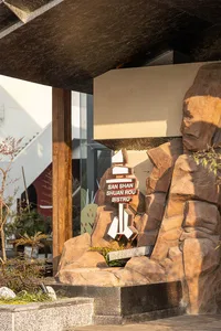 三山舜肉碧羅餐廳戶外入口，以大型立體招牌為主體，安裝在雕刻仿岩石造型上，上方有混凝土遮陽棚，底部搭配小型景觀植物。