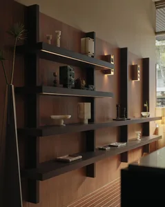 Modern dark walnut built-in floating shelves with warm integrated LED strip lighting displaying decorative objects against a wood-paneled wall