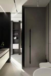 Modern minimalist bathroom interior with dark wood cabinetry, white floating vanity, built-in open shelving, matte black door, and white ceramic toilet under dramatic natural light.