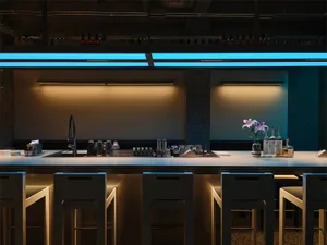 Modern industrial bar counter with four white bar stools, black faucet, and dramatic blue LED neon lighting above a concrete backdrop.