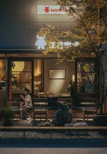 日式風格戶外咖啡座夜景，包含木椅、石燈籠、楓樹，以及透過大片玻璃窗可見的溫暖室內燈光。