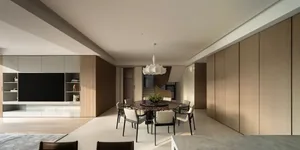 Modern minimalist dining room featuring a large round dark marble table surrounded by six light-colored dining chairs, under a white sculptural pendant lamp, with floor-to-ceiling walnut wood paneling and built-in media console in the background.