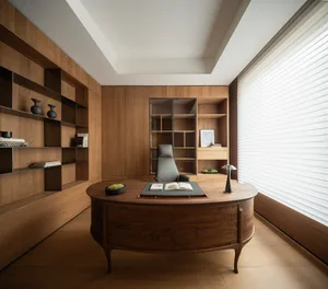 Modern home office with a large curved walnut executive desk, grey ergonomic chair, and extensive built-in wooden bookshelves lining the walls.