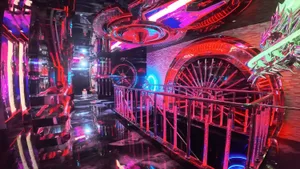 Futuristic cyberpunk nightclub interior with mirrored walls, glossy black floors, neon red and blue lighting, and a large illuminated mechanical dragon wheel installation.