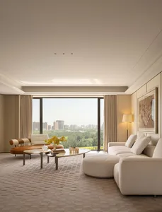Modern luxury living room featuring a large beige boucle sectional sofa, curved brown and cream leather chaise lounge, glass and metal coffee table, and floor-to-ceiling windows overlooking a green forest and city skyline.