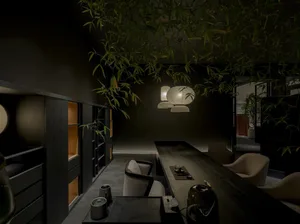 Modern Japanese-style dining room with dark wood walls and furniture, long wooden dining table, cream upholstered chairs, and multiple white paper lanterns hanging from the ceiling surrounded by hanging bamboo leaves.