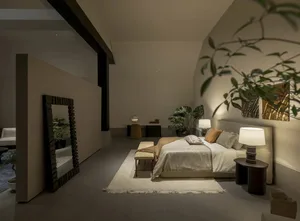 Modern minimalist bedroom with textured beige walls, large bed with neutral bedding, sculptural bedside lamps, and indoor plants in soft warm lighting.