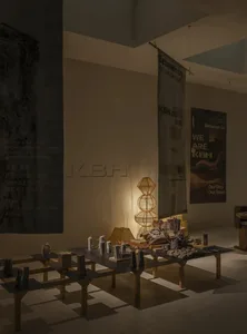 現代展位設計，長型深色展示桌陳列各式工藝品，搭配大型雕塑感竹編立燈，以及KBH與Between Us藝術生活展覽的大型直式布旗。