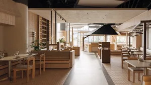 Modern minimalist restaurant interior featuring warm oak wood paneling, built-in banquette seating, wooden dining tables and chairs, large windows with abundant natural light, and a neutral beige and cream color palette.