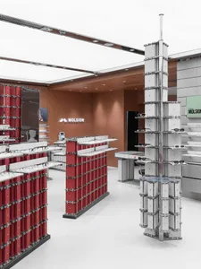 Modern optical store interior featuring tall modular display towers in red and concrete, with stainless steel frames and clean white flooring.