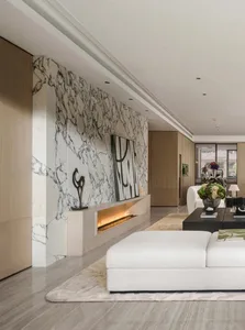 Modern luxury living room featuring a full-height white and grey marble feature wall with a recessed linear fireplace, minimalist white sectional sofa, and contemporary artwork.