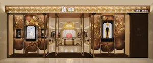Front view of a high-end jewelry store entrance featuring gilded bronze sculptural branches, traditional Chinese floral murals, crystal chandelier, and luxurious display cases.