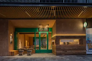 Night view of a modern dessert shop entrance with green doors, wooden counter, concrete walls and warm lighting in Taiwan.