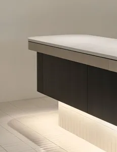 Close-up view of a modern floating bathroom vanity made of dark walnut wood with a thick white terrazzo countertop, installed above white rectangular floor tiles with integrated LED lighting underneath.