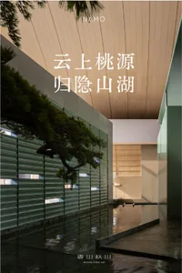 Modern indoor courtyard featuring a large bonsai pine tree extending over a shallow reflective water pond, surrounded by vertical wood paneling and concrete walls with soft natural lighting.