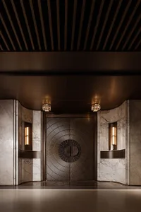 Luxurious Art Deco style entrance featuring a large bronze double door with intricate sunburst pattern, flanked by white marble walls with vertical fluting and illuminated wall sconces under a dark coffered ceiling.