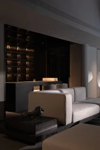 Modern minimalist living room featuring a dark concrete home bar with backlit bottle display, a light gray modular sofa, and a black geometric lion sculpture on a dark wood plinth.