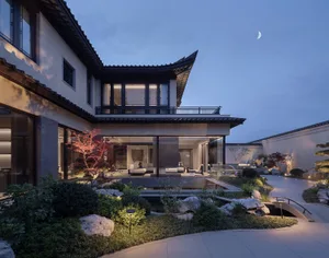 Night view of a luxurious modern Chinese villa with a tranquil courtyard garden featuring a reflecting pool, natural stone landscaping, red maple trees, and warm interior lighting visible through large glass doors.