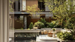 Modern luxury courtyard garden with natural stone deck, built-in seating, wooden fence, and lush green tropical plants in an urban residence.