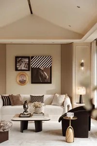 Modern neutral living room with a white curved sofa, dark velvet armchair, marble coffee table, and a gallery wall displaying black and white photography and a gold-framed Shanghai skyline portrait.