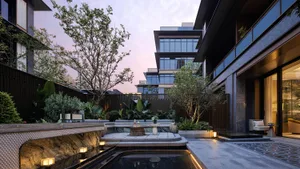 Modern luxury villa courtyard at twilight featuring a long reflecting pool, natural stone terraces, lush tropical planting, and warm ambient lighting between contemporary architectural volumes.