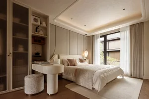 Modern luxury bedroom featuring a curved white boucle vanity desk with matching stool, neutral beige walls, large window with sheer and heavy curtains, and warm layered lighting.