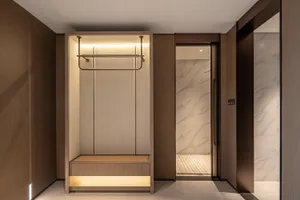 Modern minimalist walk-in closet with wood paneling, built-in clothing rack with LED lighting, tatami bench, and an adjacent marble-tiled shower visible through an open doorway.
