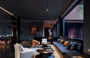 Modern dark-themed luxury living room featuring a long blue velvet sofa with orange and grey pillows, white and terracotta accent chairs, dark wood round coffee tables, and dramatic linear lighting.