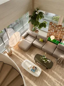 High-angle view of a bright, modern living room featuring a large beige sectional sofa, woven jute rug, organic-shaped coffee tables, a sculptural floor lamp, and a tall fiddle-leaf fig tree beside expansive windows.