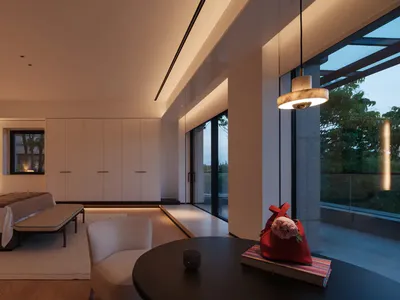 Modern minimalist bedroom interior featuring a low platform bed with white linens, built-in wood paneling, a round black coffee table with a red handbag, and large glass doors opening to a balcony at dusk.
